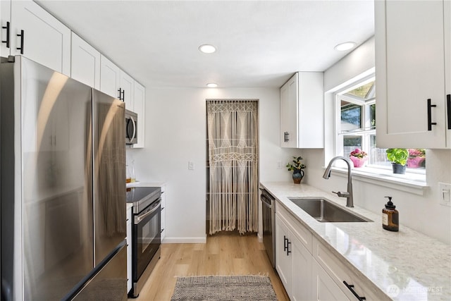 2426 Haines St, Port Townsend, WA 98368 - kitchen featuring stainless steel appliances, light wood finished floors, white cabinets, light stone countertops, and recessed lighting