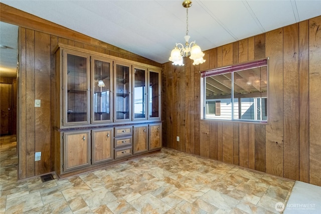 66 Onyx St, Walla Walla, WA 99362 - unfurnished room featuring wooden walls, a chandelier, and light stone finish flooring