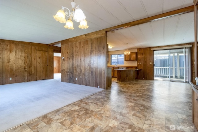 66 Onyx St, Walla Walla, WA 99362 - unfurnished living room with a chandelier, wooden walls, stone finish floors, and beam ceiling