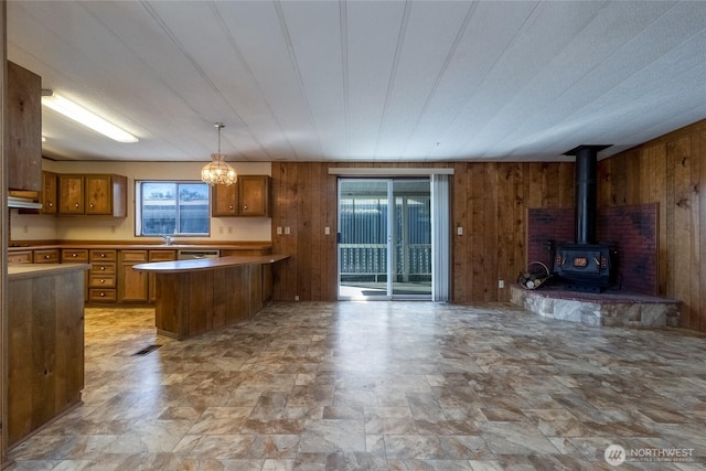 66 Onyx St, Walla Walla, WA 99362 - kitchen featuring open floor plan, wooden walls, brown cabinets, stone finish floors, and a peninsula