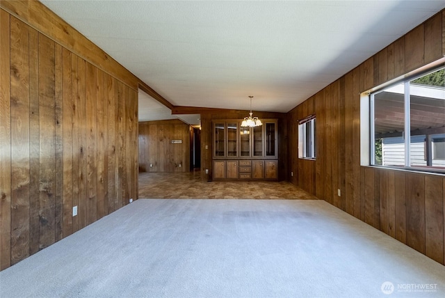 66 Onyx St, Walla Walla, WA 99362 - spare room featuring a chandelier, wooden walls, and carpet flooring