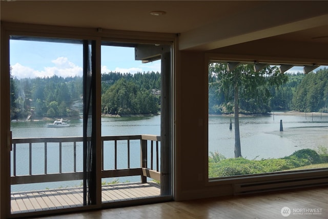 181 N Bay Ln Unit 2, Port Ludlow, WA 98165 - unfurnished sunroom with a water view, a baseboard radiator, and a forest view