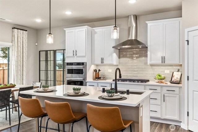 32324 135th Pl SE Unit 211, Sultan, WA 98294 - kitchen featuring wall chimney range hood, stainless steel appliances, dark wood finished floors, light countertops, and recessed lighting