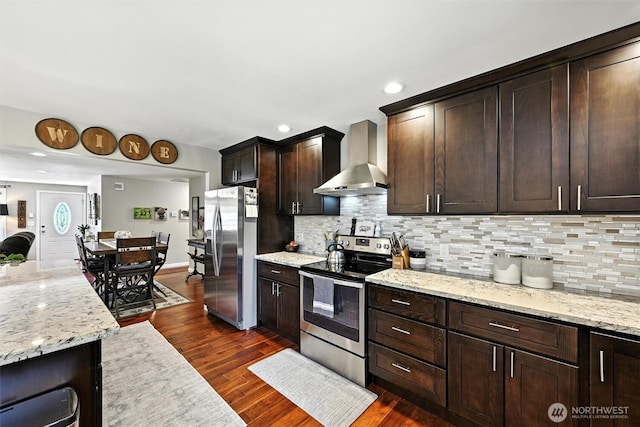 7212 188th Ave E, Bonney Lake, WA 98391 - kitchen featuring stainless steel appliances, wall chimney exhaust hood, tasteful backsplash, dark brown cabinetry, and light stone countertops