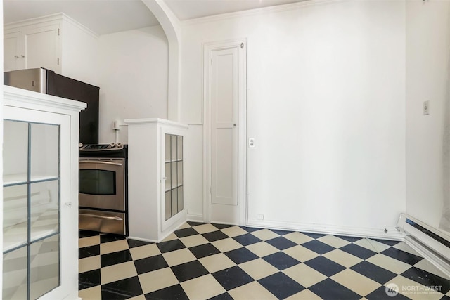 3121 Franklin Ave E Unit 24, Seattle, WA 98102 - kitchen with light floors, stainless steel electric range, white cabinets, a baseboard heating unit, and arched walkways