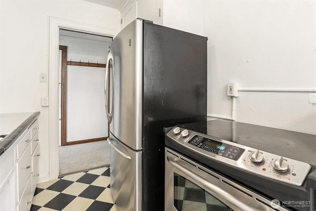 3121 Franklin Ave E Unit 24, Seattle, WA 98102 - kitchen featuring stainless steel appliances, white cabinetry, tile patterned floors, and carpet