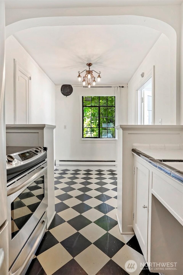 3121 Franklin Ave E Unit 24, Seattle, WA 98102 - kitchen featuring stainless steel electric range, light flooring, a chandelier, white cabinetry, and baseboard heating