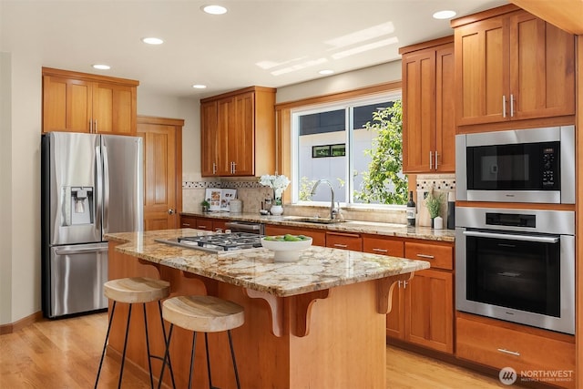 11226 NE 67th St, Kirkland, WA 98033 - kitchen with appliances with stainless steel finishes, light wood-style floors, recessed lighting, a breakfast bar, and backsplash