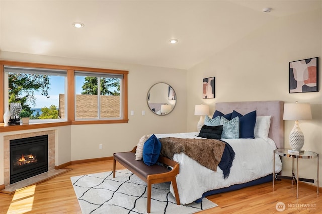 11226 NE 67th St, Kirkland, WA 98033 - bedroom featuring wood finished floors, a tiled fireplace, lofted ceiling, and recessed lighting