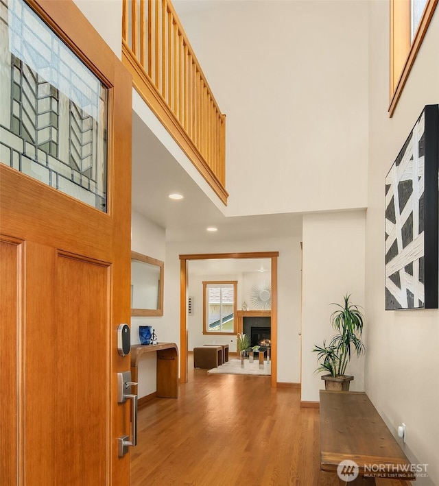 11226 NE 67th St, Kirkland, WA 98033 - entryway featuring a towering ceiling, wood finished floors, recessed lighting, and a warm lit fireplace