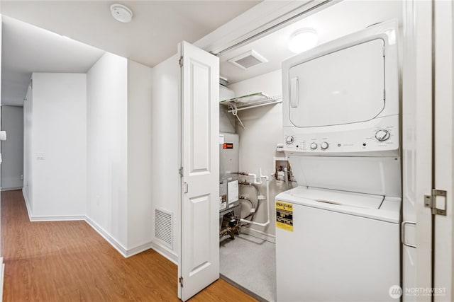 819 Virginia St Unit 2408, Seattle, WA 98101 - washroom featuring stacked washer / drying machine, light wood-style flooring, and water heater
