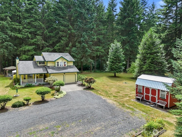 103 Nikula Rd W, Winlock, WA 98596 - view of front of house featuring covered porch, driveway, a front yard, an attached garage, and a wooded view