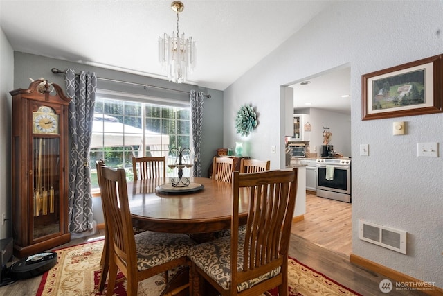 103 Nikula Rd W, Winlock, WA 98596 - dining area with lofted ceiling, light wood finished floors, a chandelier, and a textured wall