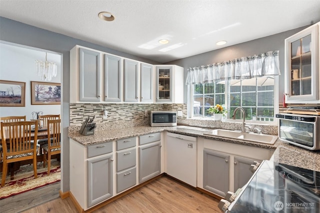 103 Nikula Rd W, Winlock, WA 98596 - kitchen with white dishwasher, stainless steel microwave, light wood-style floors, tasteful backsplash, and a chandelier