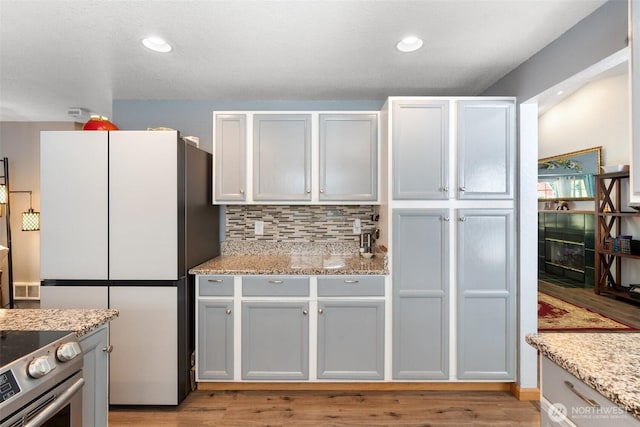 103 Nikula Rd W, Winlock, WA 98596 - kitchen with freestanding refrigerator, stainless steel electric stove, backsplash, light wood-style flooring, and recessed lighting
