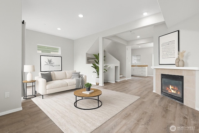 8077 165th Ln NE, Redmond, WA 98052 - living room featuring light wood-style flooring, a tiled fireplace, and recessed lighting