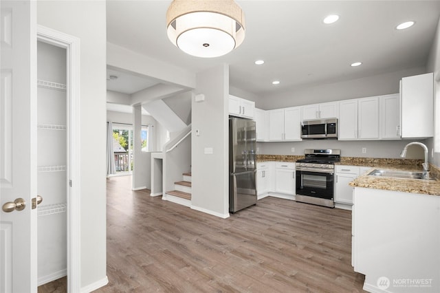 8077 165th Ln NE, Redmond, WA 98052 - kitchen featuring stainless steel appliances, light wood finished floors, recessed lighting, light stone countertops, and white cabinetry