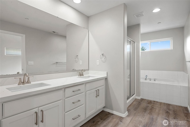 8077 165th Ln NE, Redmond, WA 98052 - full bath with a bath, a shower stall, double vanity, wood finished floors, and recessed lighting
