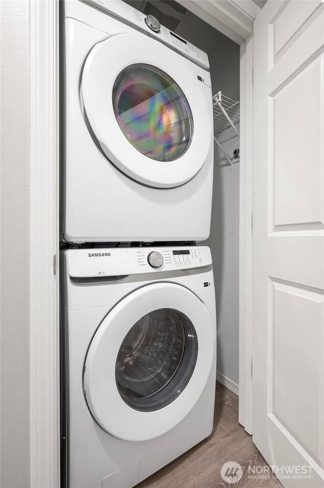8077 165th Ln NE, Redmond, WA 98052 - laundry area with stacked washer / drying machine and wood finished floors