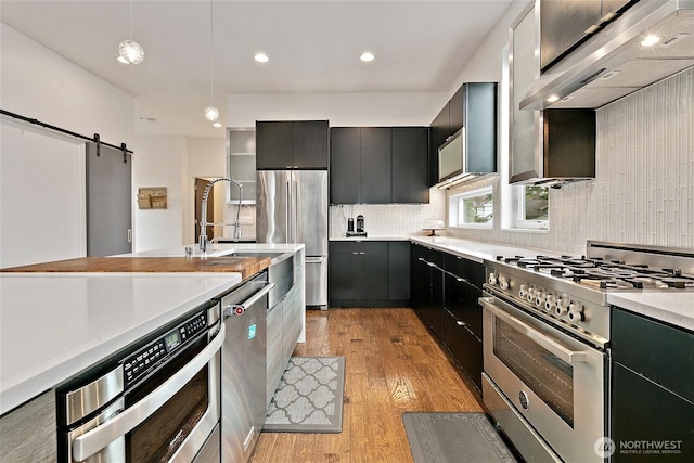 4113 Palatine Ave N, Seattle, WA 98103 - kitchen with stainless steel appliances, light countertops, light wood-style floors, backsplash, and exhaust hood