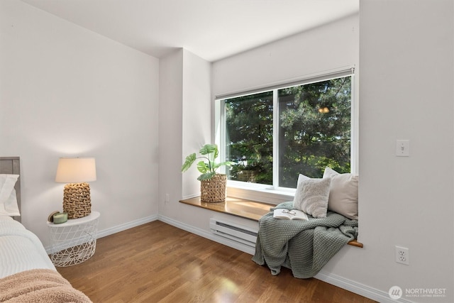 3112 SW Avalon Way Unit 102, Seattle, WA 98126 - living area featuring a baseboard radiator, healthy amount of natural light, and wood finished floors