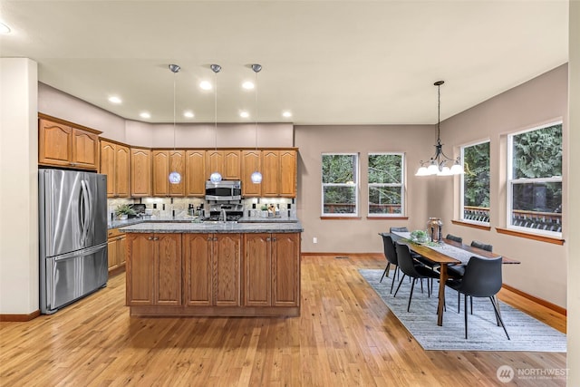 8 Southern Ct, Bellingham, WA 98229 - kitchen with stainless steel appliances, brown cabinets, backsplash, light wood-style floors, and hanging light fixtures