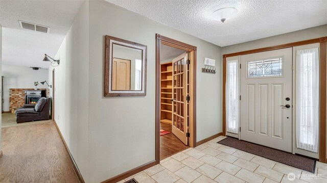 16621 148th Ave SE, Renton, WA 98058 - entrance foyer featuring a textured ceiling, a wood stove, and light tile patterned floors