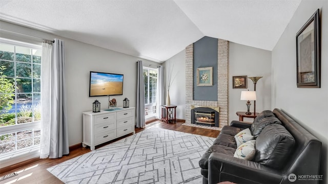 16621 148th Ave SE, Renton, WA 98058 - living area featuring vaulted ceiling, wood finished floors, healthy amount of natural light, a brick fireplace, and a textured ceiling