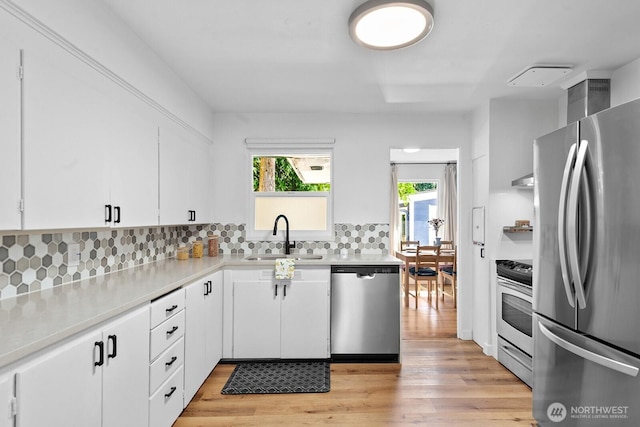 1528 NE 166th St, Shoreline, WA 98155 - kitchen with stainless steel appliances, light countertops, light wood-style floors, backsplash, and white cabinetry