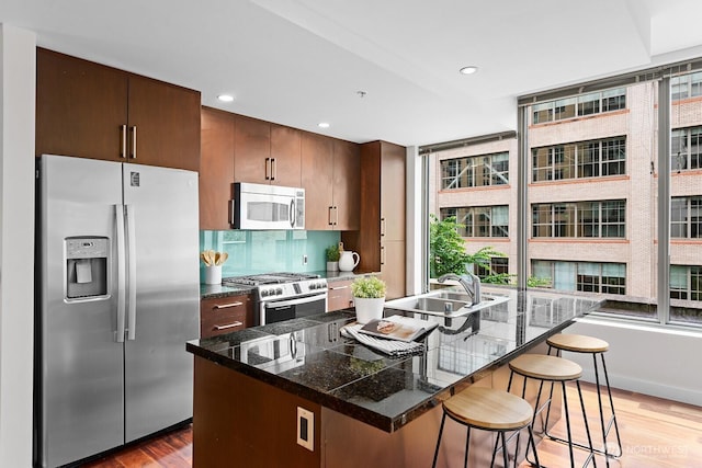 910 Lenora St Unit S403, Seattle, WA 98121 - kitchen with stainless steel appliances, light wood-type flooring, a breakfast bar area, tile countertops, and a kitchen island with sink