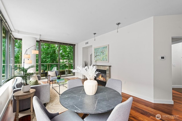 910 Lenora St Unit S403, Seattle, WA 98121 - dining space with a glass covered fireplace, wood finished floors, floor to ceiling windows, and plenty of natural light