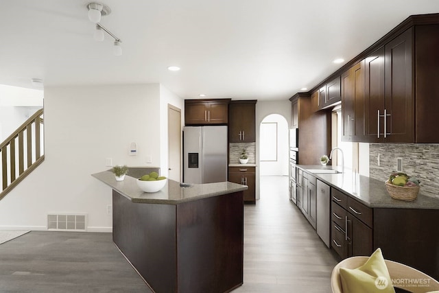 34801 30th Ave SW, Federal Way, WA 98023 - kitchen with stainless steel appliances, arched walkways, dark brown cabinetry, decorative backsplash, and recessed lighting