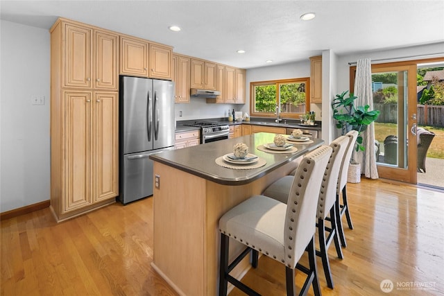 23303 13th Pl W, Bothell, WA 98021 - kitchen featuring stainless steel appliances, a kitchen bar, light wood-style flooring, under cabinet range hood, and recessed lighting