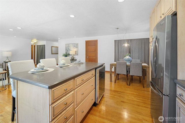 23303 13th Pl W, Bothell, WA 98021 - kitchen with freestanding refrigerator, wine cooler, light wood-style floors, dark countertops, and a center island