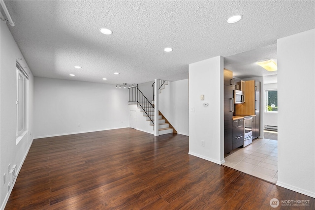 24814 SE 145th Ln, Kent, WA 98042 - unfurnished living room featuring a textured ceiling, wood finished floors, stairway, recessed lighting, and a baseboard heating unit