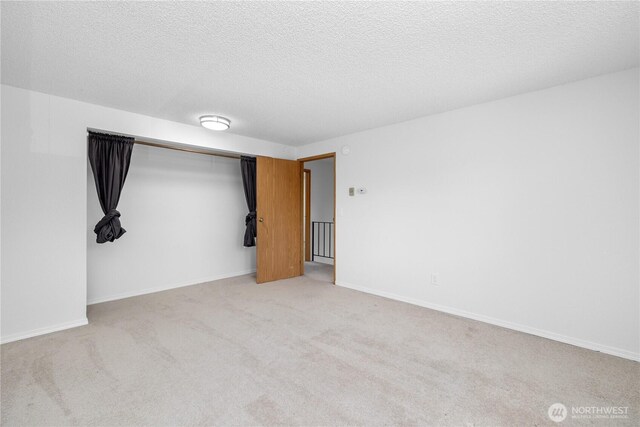 24814 SE 145th Ln, Kent, WA 98042 - unfurnished bedroom featuring light carpet, a textured ceiling, and a closet