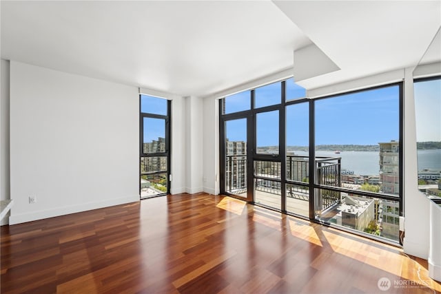 2911 2nd Ave Unit 1117, Seattle, WA 98121 - empty room with healthy amount of natural light, expansive windows, a water view, and wood finished floors
