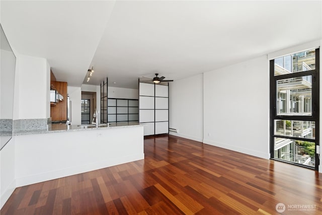 2911 2nd Ave Unit 1117, Seattle, WA 98121 - unfurnished living room featuring a ceiling fan and dark wood finished floors