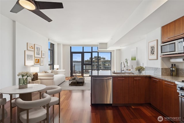 2911 2nd Ave Unit 1117, Seattle, WA 98121 - kitchen featuring white microwave, stainless steel dishwasher, a peninsula, dark wood-style flooring, and expansive windows