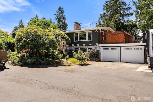 22616 88th Ave W, Edmonds, WA 98026 - view of front of property featuring a balcony, a chimney, concrete driveway, and stone siding
