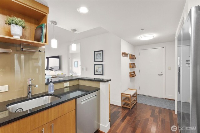 1415 2nd Ave NE Unit 1801, Seattle, WA 98101 - kitchen with stainless steel appliances, dark wood finished floors, dark stone countertops, decorative light fixtures, and brown cabinetry