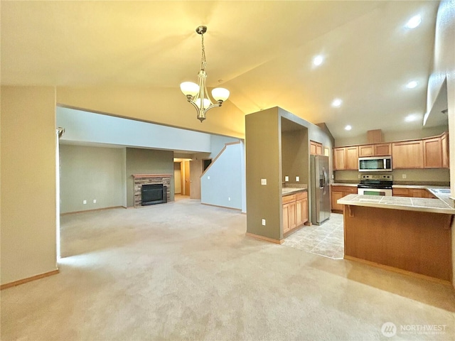 4544 Durham St SE, Lacey, WA 98503 - kitchen featuring stainless steel appliances, lofted ceiling, light colored carpet, open floor plan, and a fireplace