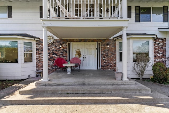 7707 42nd Ave E, Tacoma, WA 98443 - entrance to property featuring a balcony, brick siding, and covered porch