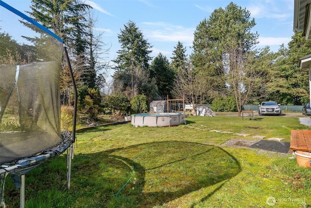 7707 42nd Ave E, Tacoma, WA 98443 - view of green lawn with a trampoline and an outdoor pool