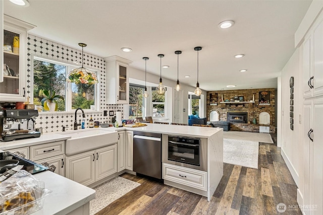 7707 42nd Ave E, Tacoma, WA 98443 - kitchen featuring stainless steel appliances, a peninsula, plenty of natural light, open floor plan, and recessed lighting