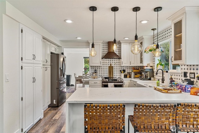 7707 42nd Ave E, Tacoma, WA 98443 - kitchen with appliances with stainless steel finishes, wall chimney exhaust hood, a peninsula, tasteful backsplash, and glass insert cabinets