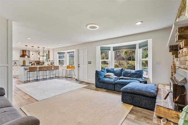 7707 42nd Ave E, Tacoma, WA 98443 - living room featuring healthy amount of natural light, a fireplace, light wood-style floors, and recessed lighting