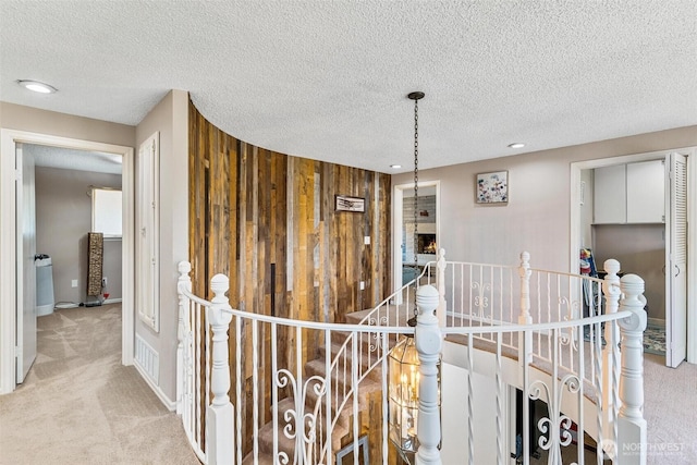 7707 42nd Ave E, Tacoma, WA 98443 - corridor with an upstairs landing, carpet floors, a textured ceiling, wooden walls, and recessed lighting