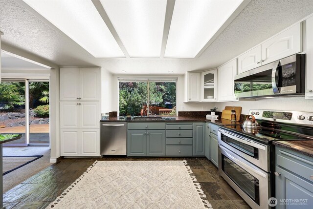 207 215th St SE, Bothell, WA 98021 - kitchen with appliances with stainless steel finishes, gray cabinetry, dark countertops, white cabinets, and plenty of natural light