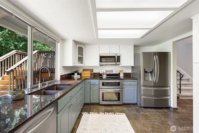 207 215th St SE, Bothell, WA 98021 - kitchen featuring stainless steel appliances, dark stone counters, white cabinetry, glass insert cabinets, and recessed lighting